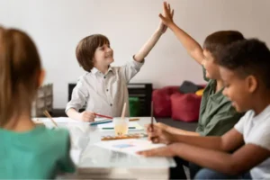 Crianças comemorando o sucesso de um projeto em equipe, representando empreendedorismo para crianças.